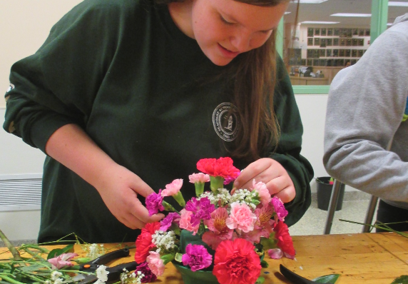 A student working on a bouquet of flowers
